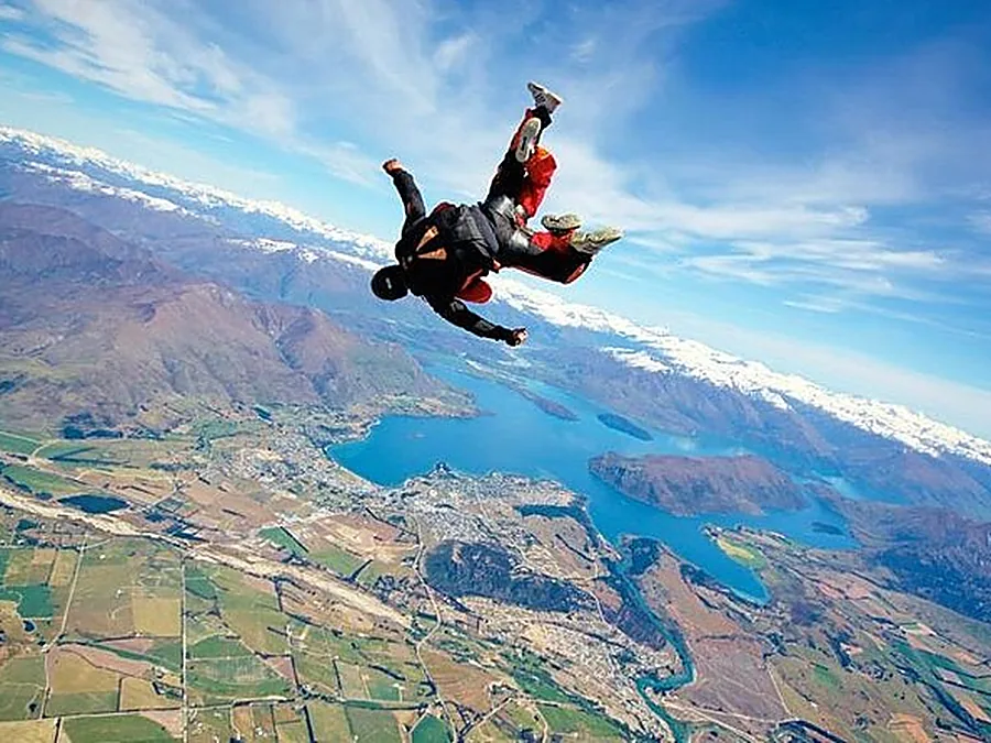 Un duo en tandem en chute libre au-dessus de lacs et de terres agricoles